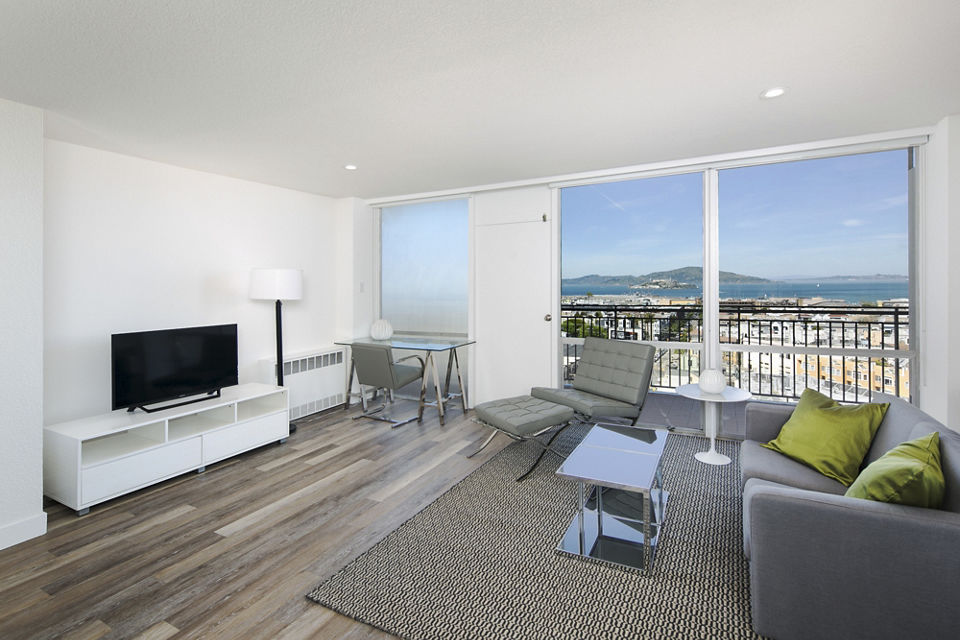 Spacious living room with elegant decor at Crystal Tower Apartments, featuring floor-to-ceiling windows and contemporary furniture