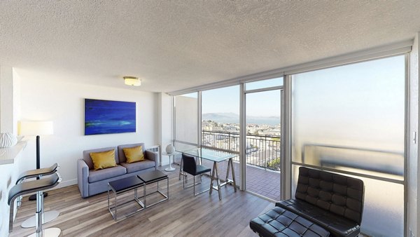 Modern living room with plush seating and natural light in Crystal Tower Apartments, luxury space for comfort and style