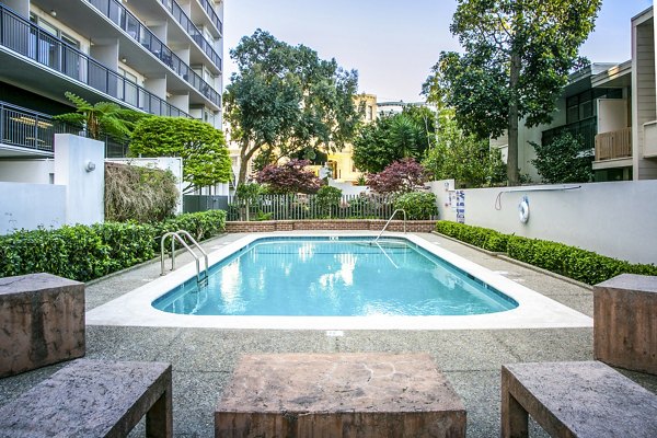Modern outdoor pool area at Crystal Tower Apartments, offering a luxurious retreat with comfortable lounge chairs and city views