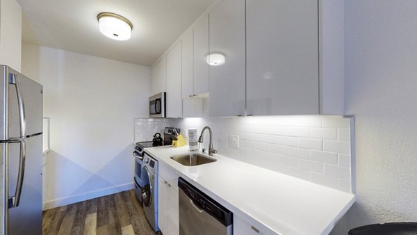 Modern kitchen with stainless steel appliances and granite countertops at Marina Cove Apartments