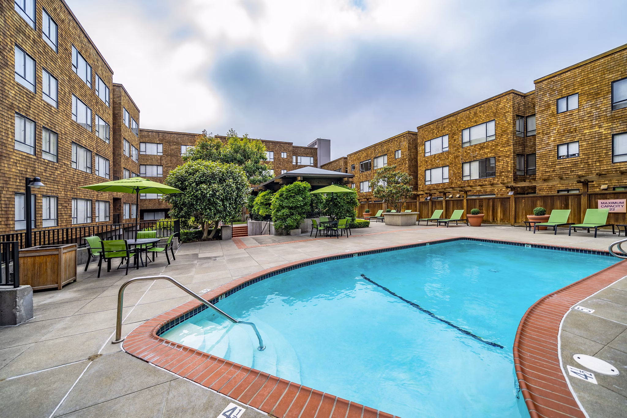 Pool with sun loungers and garden views at Marina Cove Apartments, a luxury residence by Greystar
