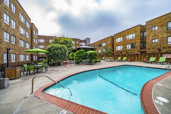 Pool with sun loungers and garden views at Marina Cove Apartments, a luxury residence by Greystar