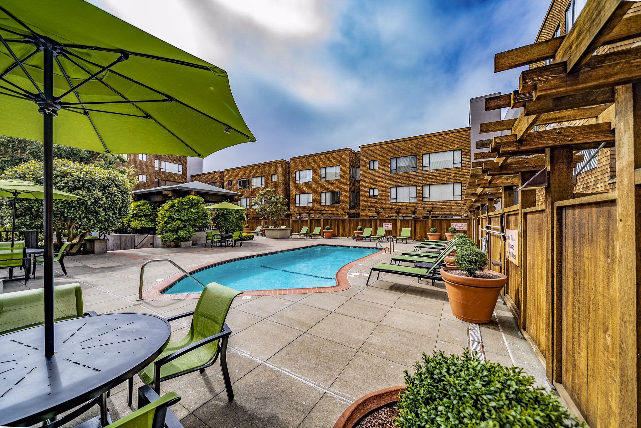 Sparkling outdoor pool at Marina Cove Apartments with sun loungers and palm trees, perfect for relaxation and leisure activities