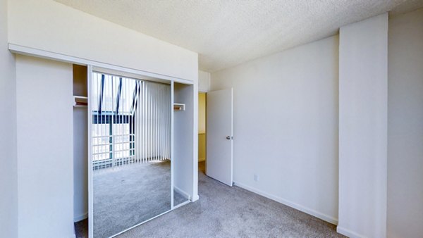 Bedroom with modern decor and ample natural light at Trinity Towers Apartments