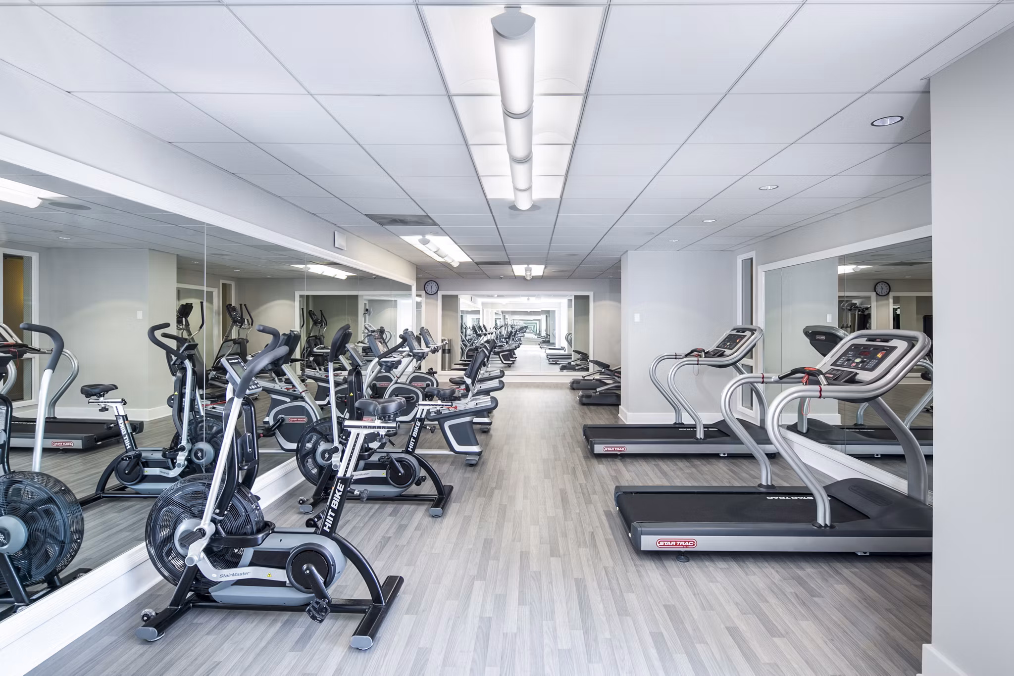 Modern fitness center with cardio and weight equipment at Trinity Towers Apartments