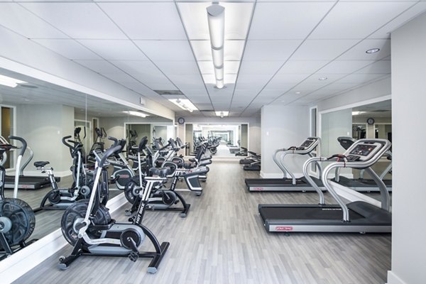 Modern fitness center with cardio and weight equipment at Trinity Towers Apartments
