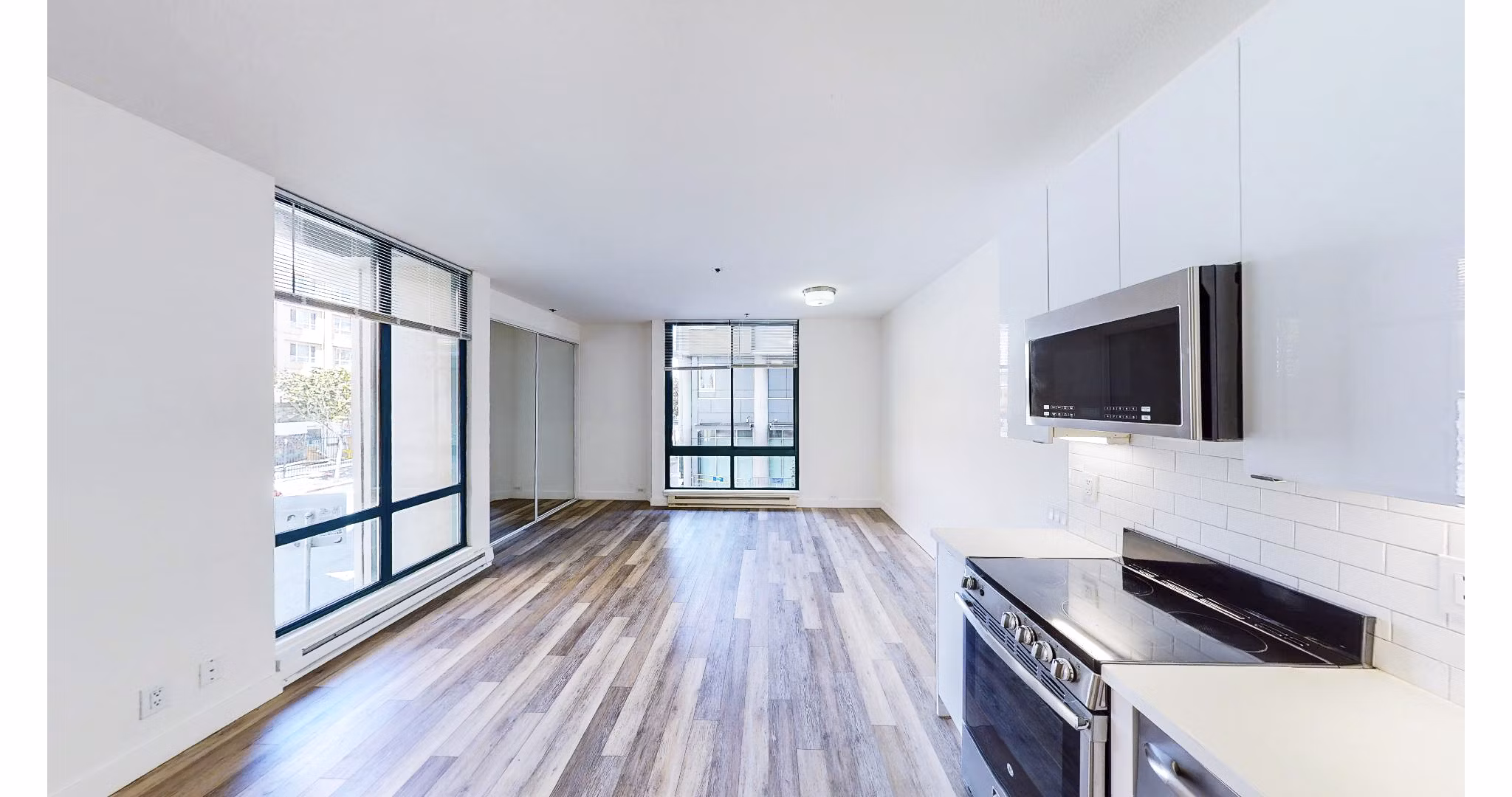 Modern kitchen featuring stainless steel appliances and granite countertops in Trinity Towers Apartments, a luxury Greystar property