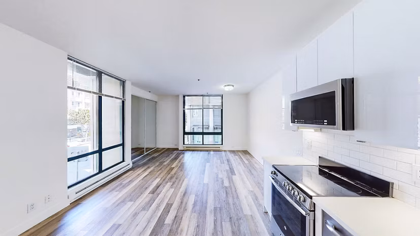 Modern kitchen featuring stainless steel appliances and granite countertops in Trinity Towers Apartments, a luxury Greystar property