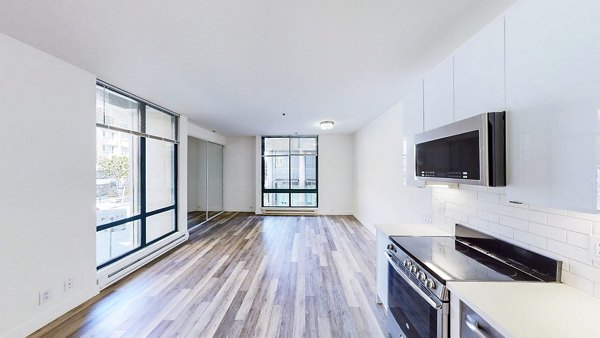 Modern kitchen featuring stainless steel appliances and granite countertops in Trinity Towers Apartments, a luxury Greystar property