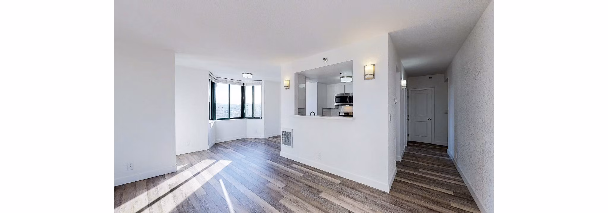 Spacious living room with contemporary design at Trinity Towers Apartments featuring large windows and modern furnishings