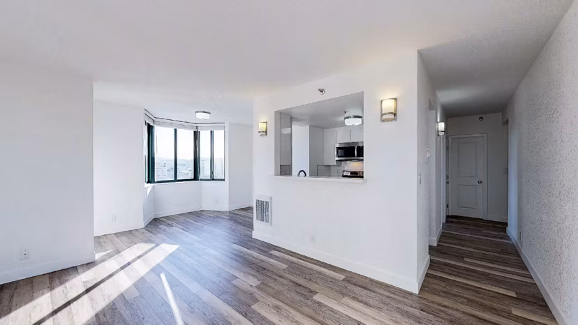 Spacious living room with contemporary design at Trinity Towers Apartments featuring large windows and modern furnishings