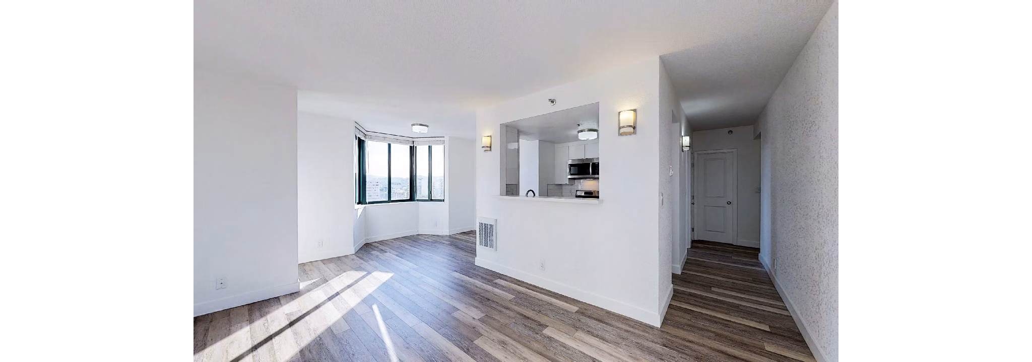 Spacious living room with contemporary design at Trinity Towers Apartments featuring large windows and modern furnishings