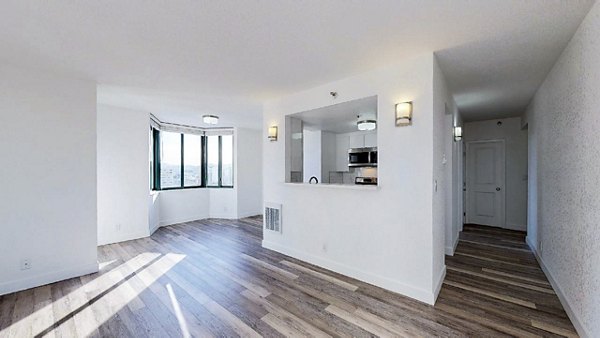Spacious living room with contemporary design at Trinity Towers Apartments featuring large windows and modern furnishings