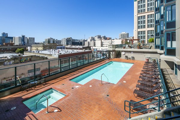 Modern outdoor pool with lounge seating at Trinity Towers Apartments
