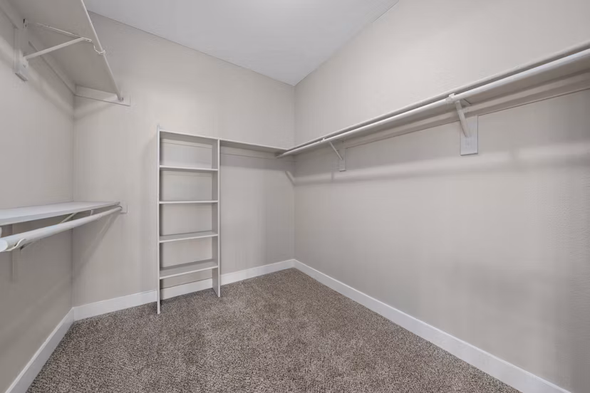 Walk-in closet with custom shelving in The Met at 3rd and Fillmore Apartments