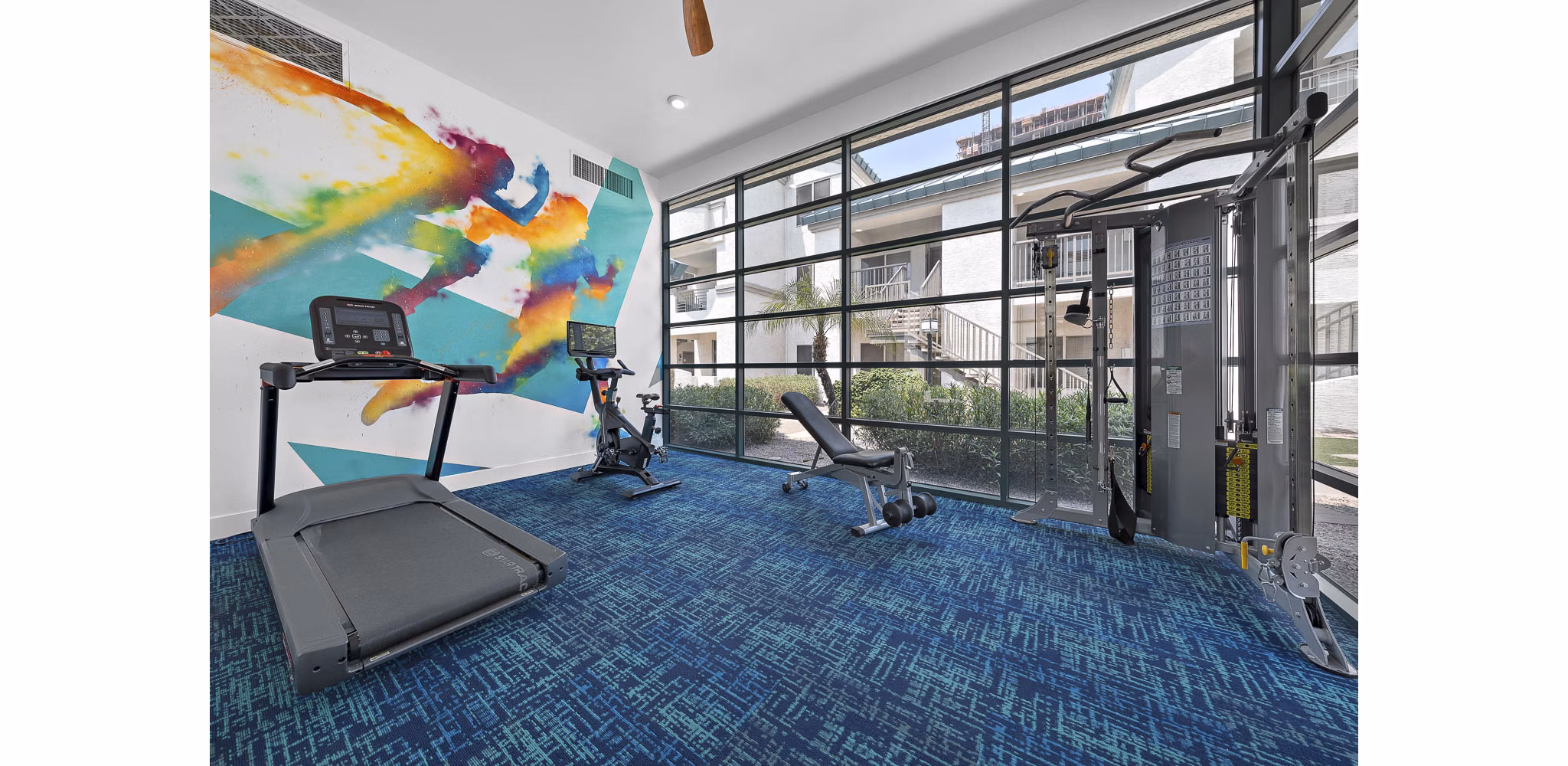 State-of-the-art fitness center with cardio machines at The Met at 3rd and Fillmore Apartments