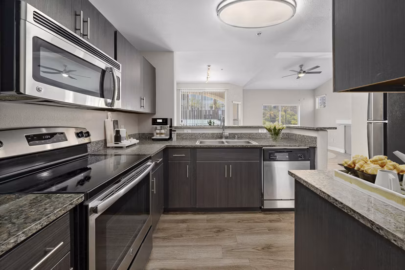Kitchen with sleek cabinetry and modern appliances at The Met at 3rd and Fillmore Apartments