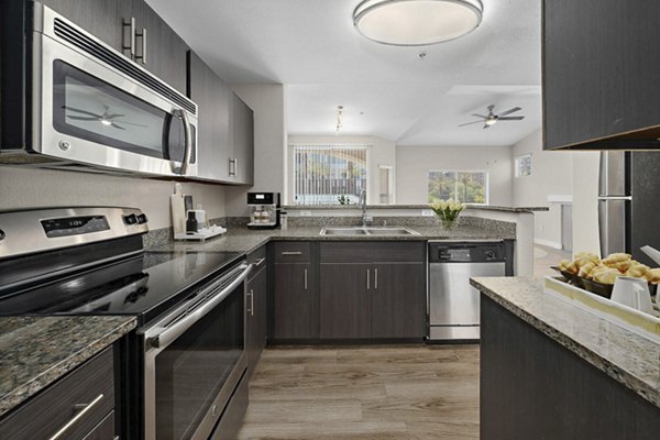 Kitchen with sleek cabinetry and modern appliances at The Met at 3rd and Fillmore Apartments