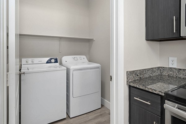 Laundry room with high-efficiency washers and dryers at The Met at 3rd and Fillmore Apartments