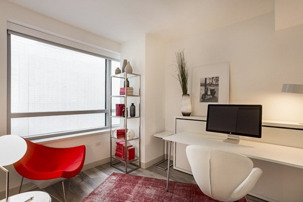 33 8th St Apartments: Cozy bedroom with modern decor in luxury Greystar apartment
