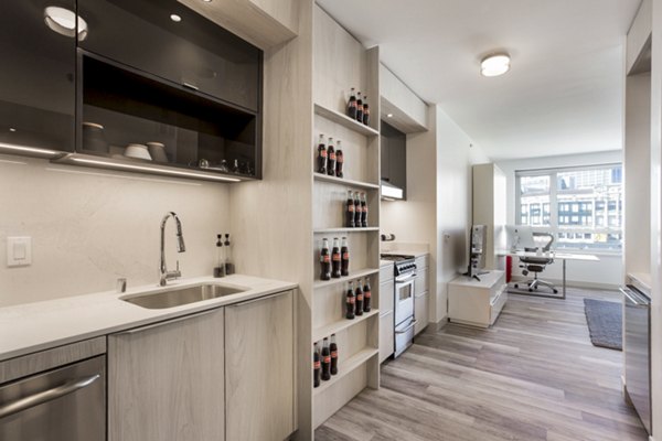 Modern kitchen with stainless steel appliances and quartz countertops at 33 8th St Apartments