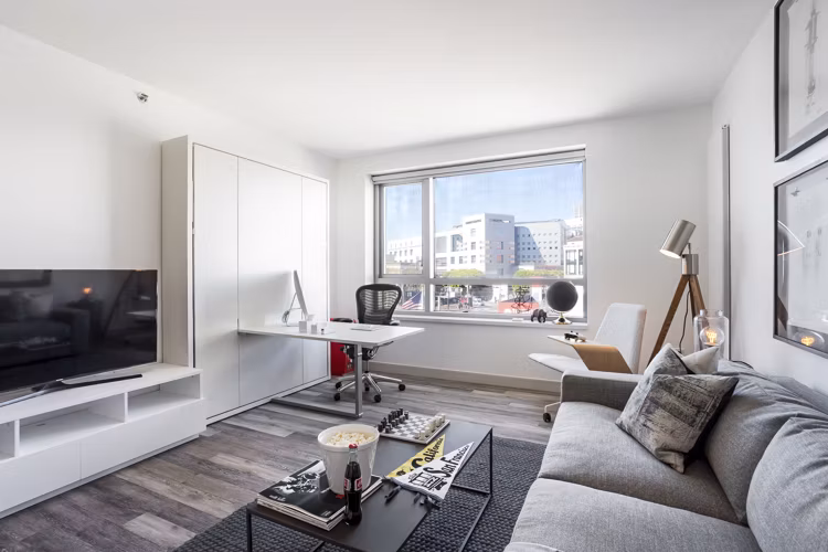 Bright, modern living room with expansive windows at 33 8th St Apartments in San Francisco