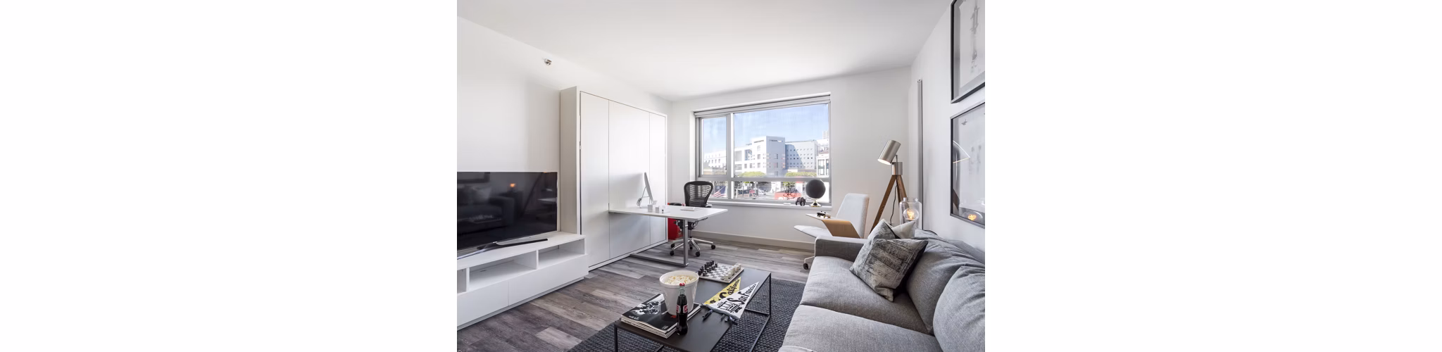 Bright, modern living room with expansive windows at 33 8th St Apartments in San Francisco