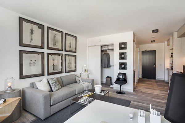 Spacious living room with modern decor and ample natural light at 33 8th St Apartments, a Greystar luxury community in Boston