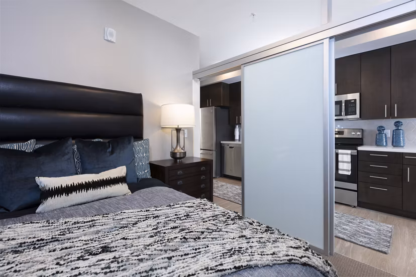 Luxury bedroom with modern decor at Baxter on Broadway Apartments, featuring stylish furnishings and ample natural light