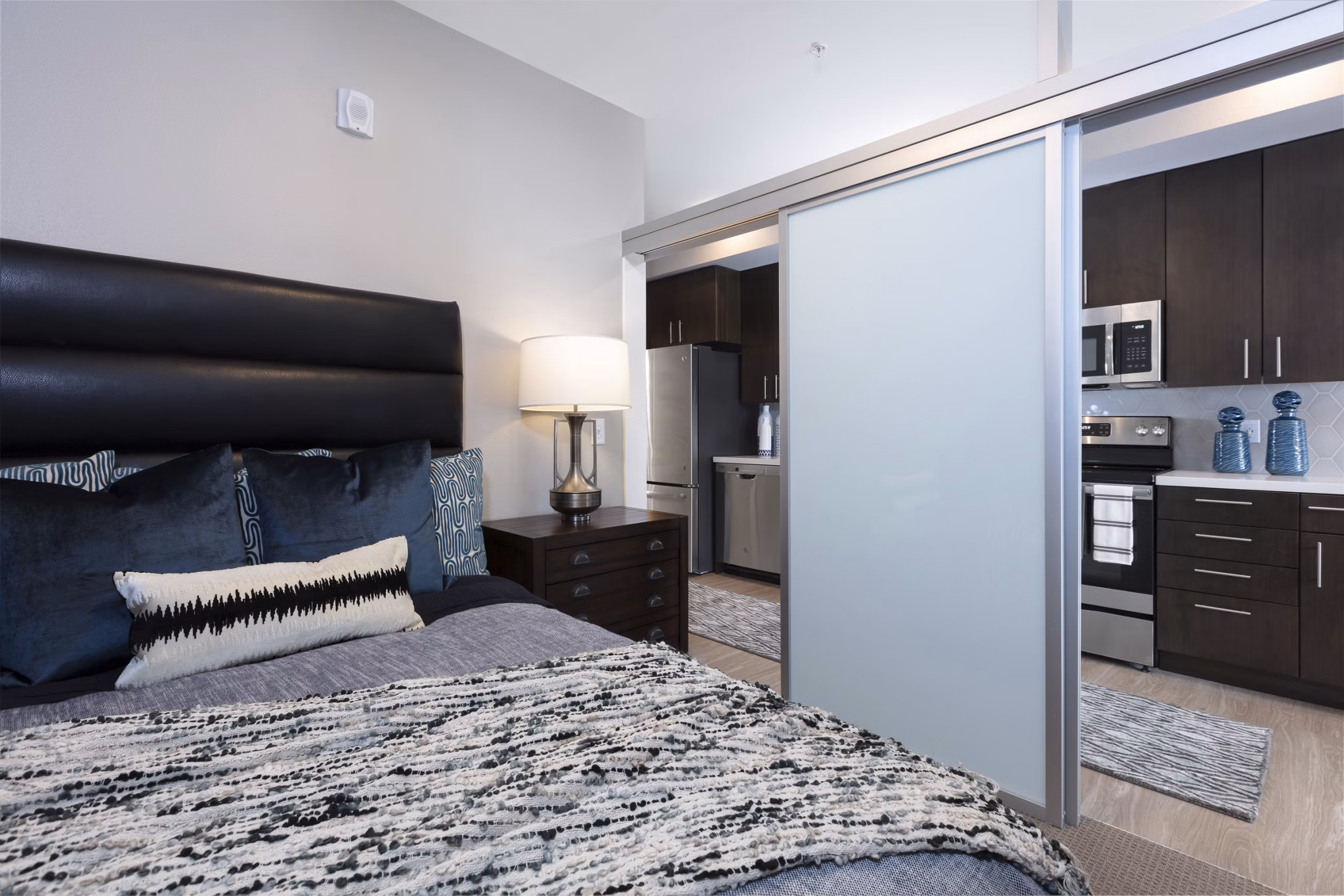 Luxury bedroom with modern decor at Baxter on Broadway Apartments, featuring stylish furnishings and ample natural light