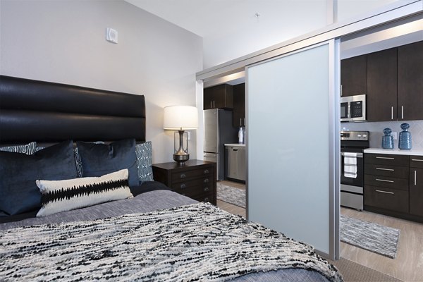 Luxury bedroom with modern decor at Baxter on Broadway Apartments, featuring stylish furnishings and ample natural light