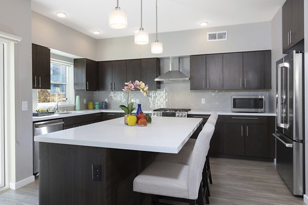 Modern kitchen with stainless steel appliances at Baxter on Broadway Apartments
