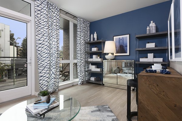 Modern living room with stylish decor and ample natural light at Baxter on Broadway Apartments
