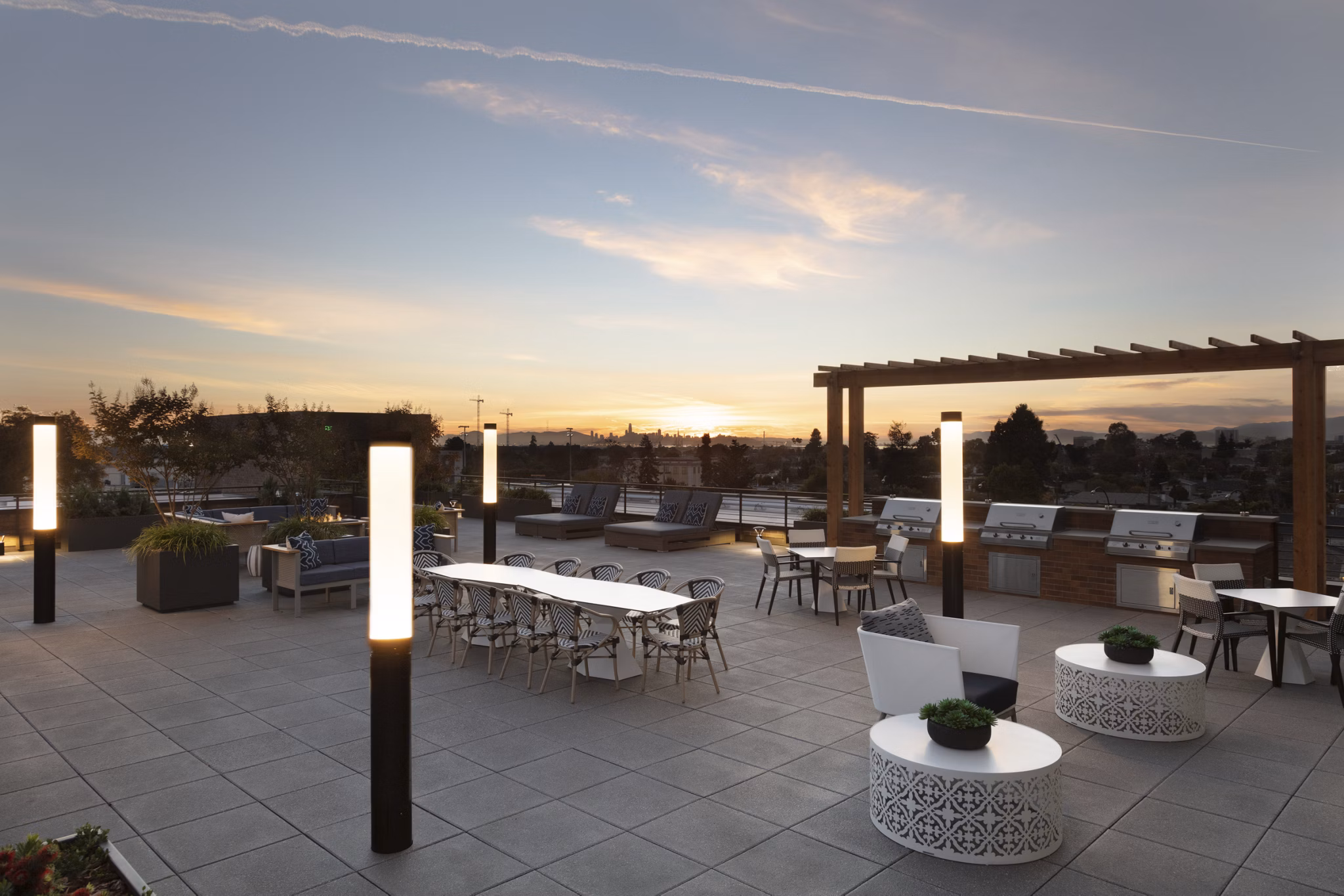Outdoor grill area with modern seating at Baxter on Broadway Apartments, Oakland
