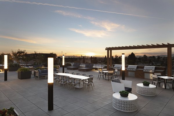 Outdoor grill area with modern seating at Baxter on Broadway Apartments, Oakland