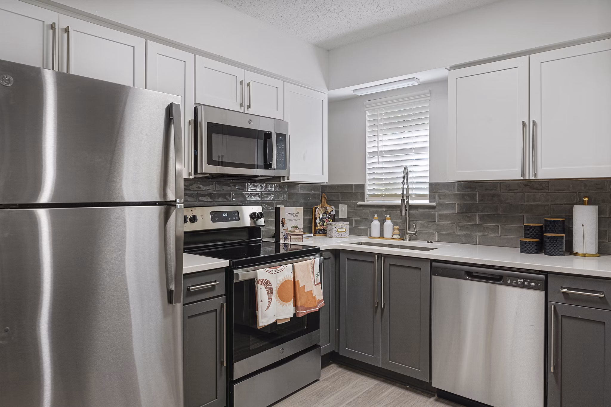 Modern kitchen with stainless steel appliances and granite countertops in Aventura Bellevue Apartments Luxurious living with Greystar's high standards