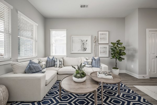 Living room with modern decor and large windows at Wingspan at Bridgeland Apartments, luxury rental in Cypress, Texas