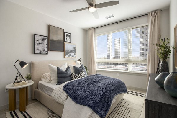 Modern bedroom with stylish decor and natural light at AVRA at RidgeGate Station Apartments