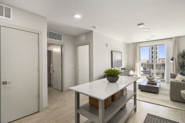 Modern kitchen with stainless steel appliances and quartz countertops in AVRA at RidgeGate Station Apartments