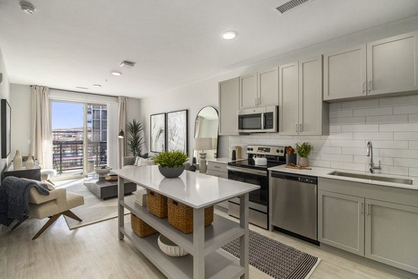Modern kitchen with stainless steel appliances at AVRA at RidgeGate Station Apartments