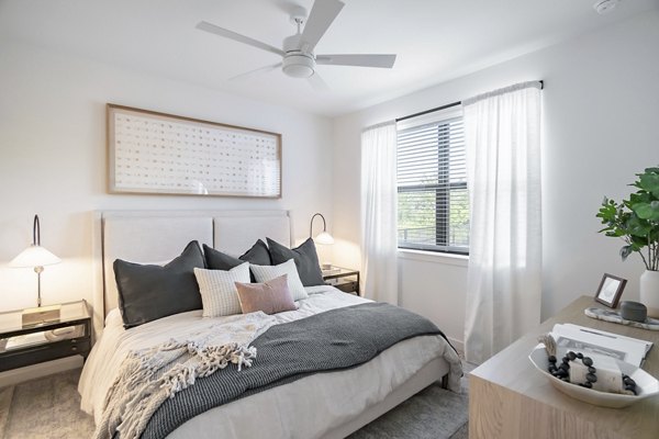 Bedroom with modern decor and natural lighting at Citizen House Bergstrom Apartments