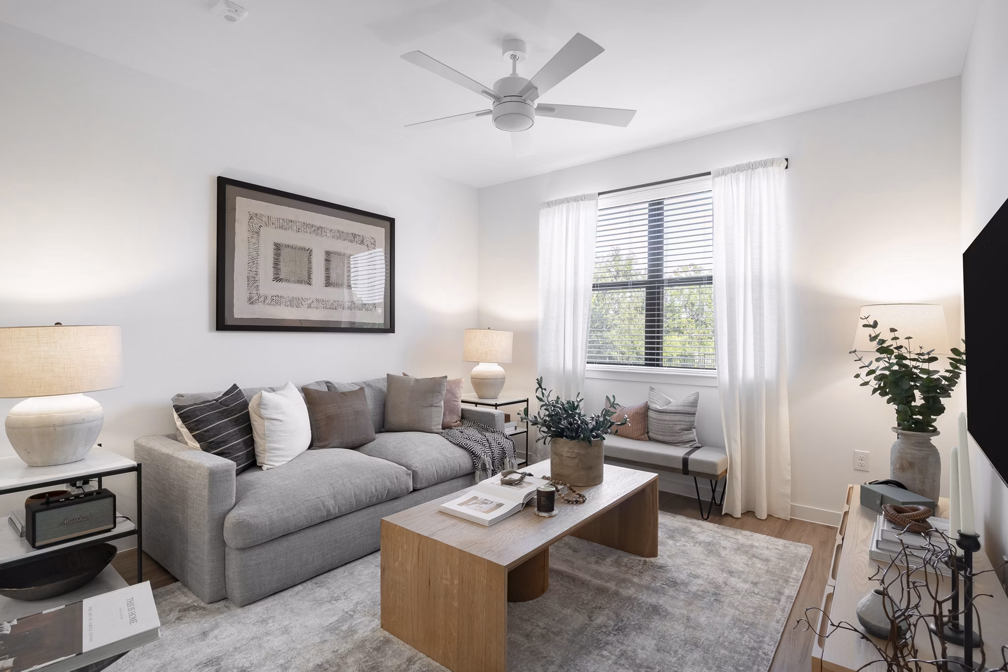 Modern living room featuring stylish furnishings and natural light at Citizen House Bergstrom Apartments
