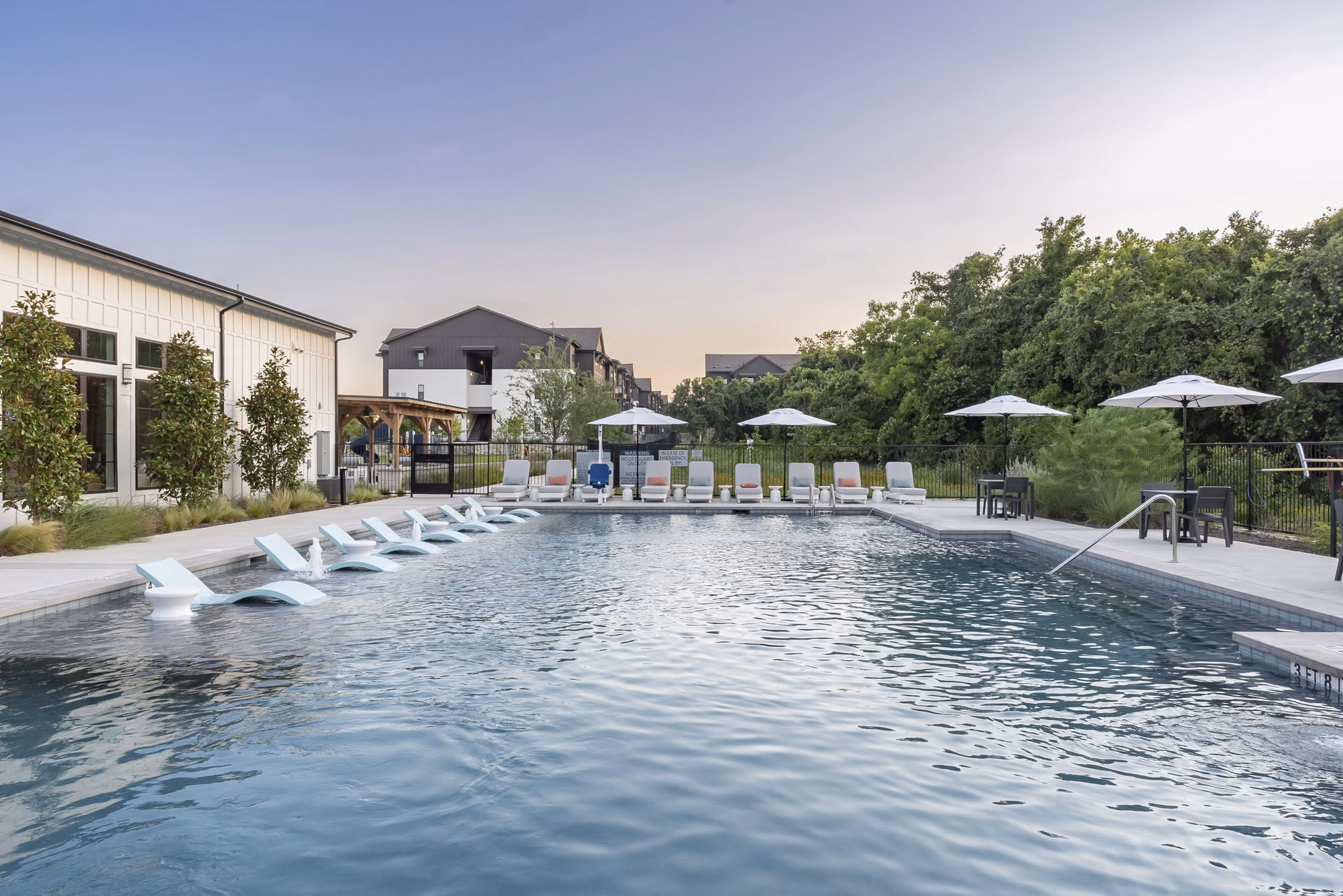 Resort-style pool area with lounge chairs and cabanas at Citizen House Bergstrom Apartments, perfect for relaxation and social gatherings