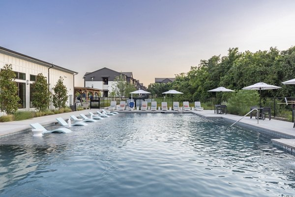 Resort-style pool area with lounge chairs and cabanas at Citizen House Bergstrom Apartments, perfect for relaxation and social gatherings