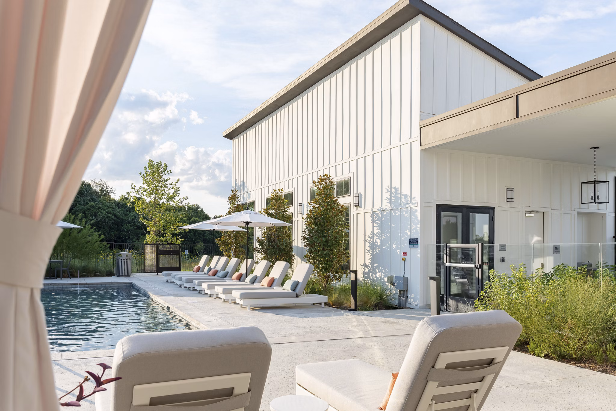 Resort-style pool with lounge chairs at Citizen House Bergstrom Apartments