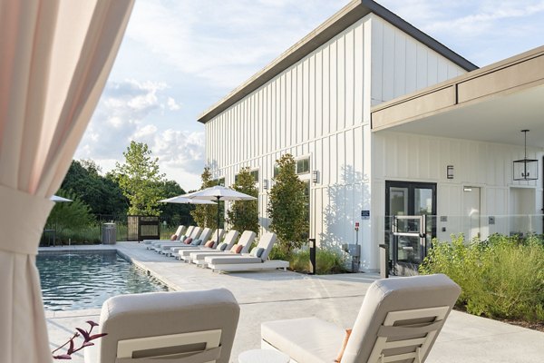 Resort-style pool with lounge chairs at Citizen House Bergstrom Apartments