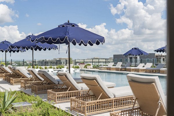Resort-style outdoor pool at Solomon Apartments with lush surroundings, perfect for relaxation and leisure living in luxury