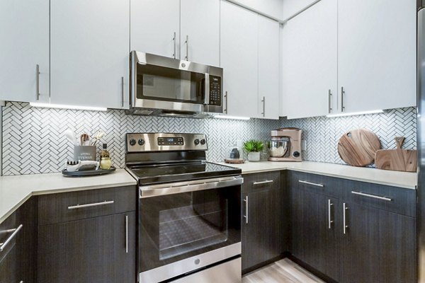 Modern kitchen with sleek countertops and stainless steel appliances at Markana Uptown Apartments