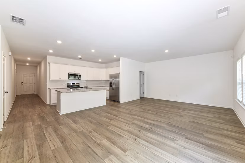 Modern kitchen with granite countertops and stainless steel appliances in Summerwell Deerhaven Apartments