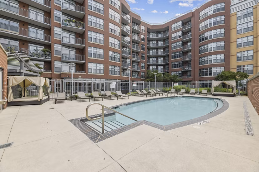 Modern pool area featuring sun loungers at Jasper Columbia Pike Apartments